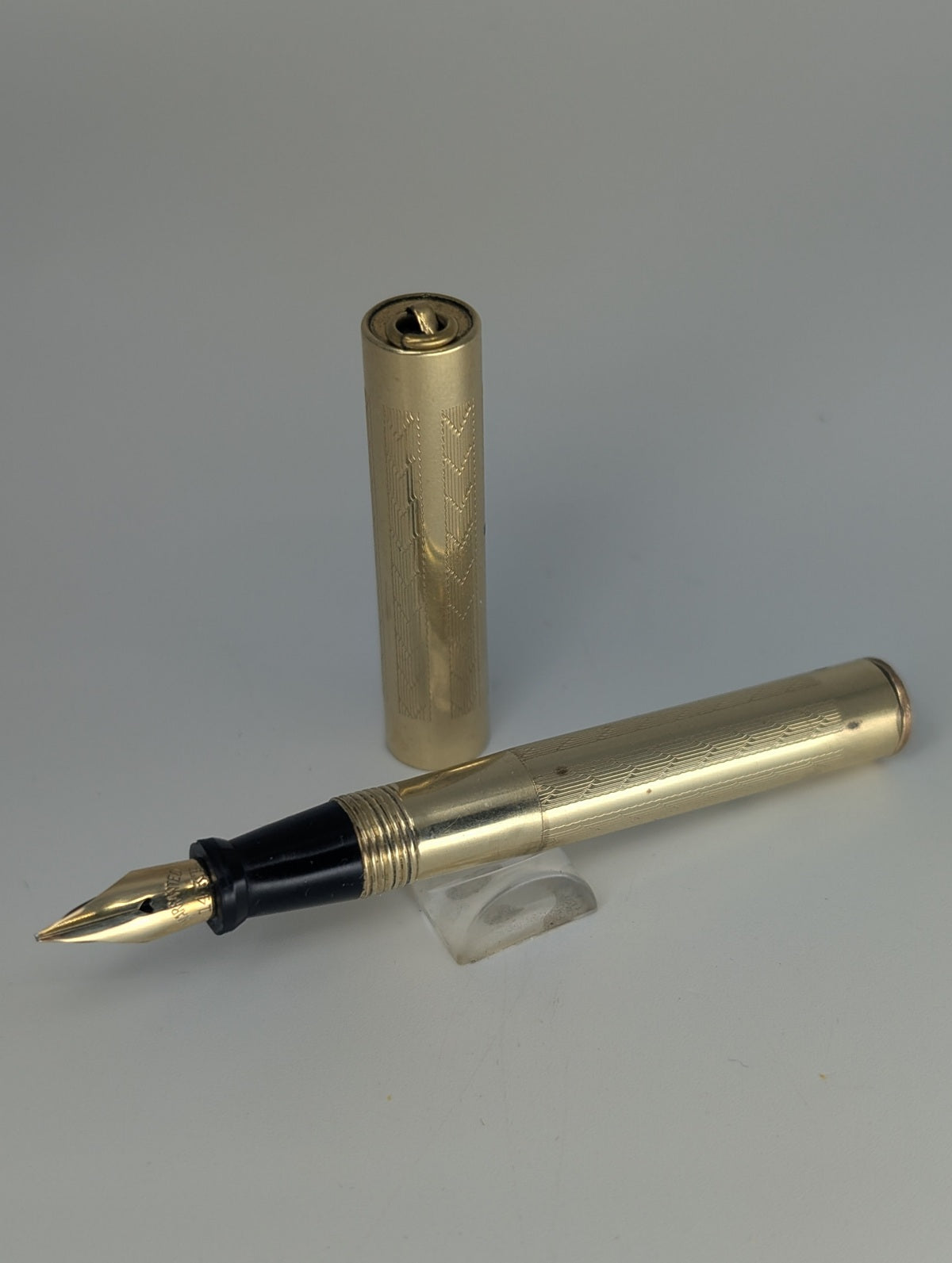 Nu-Point Gold fountain pen on a gray background