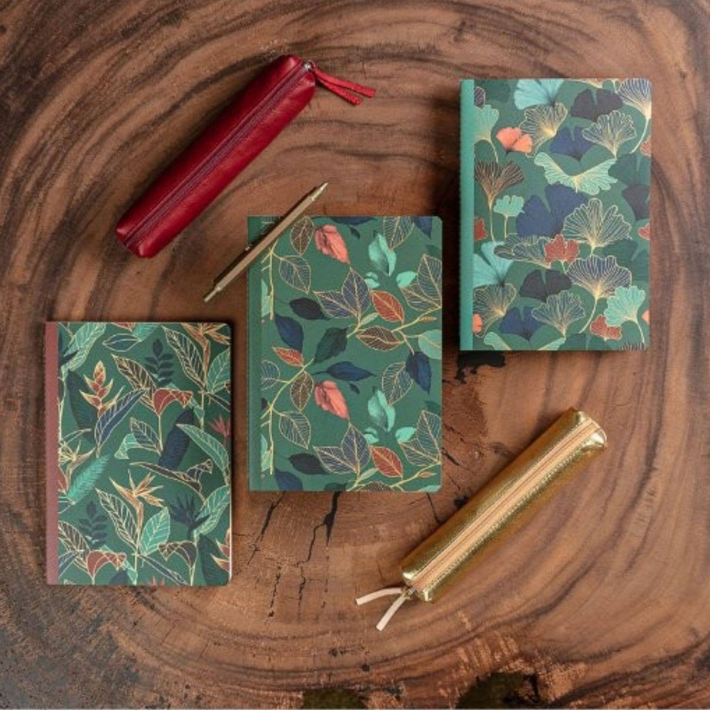 Set of notebooks with floral patterns on a wooden surface