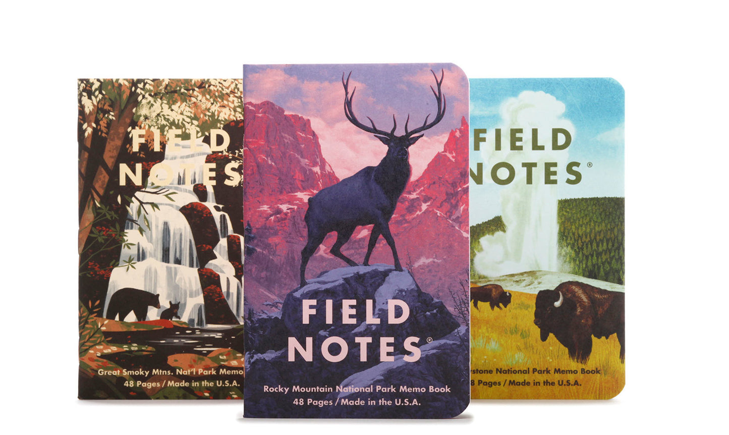 Three Field Notes memo books, each with a colorful illustration of a national park scene including mountains, a forest, and wildlife.