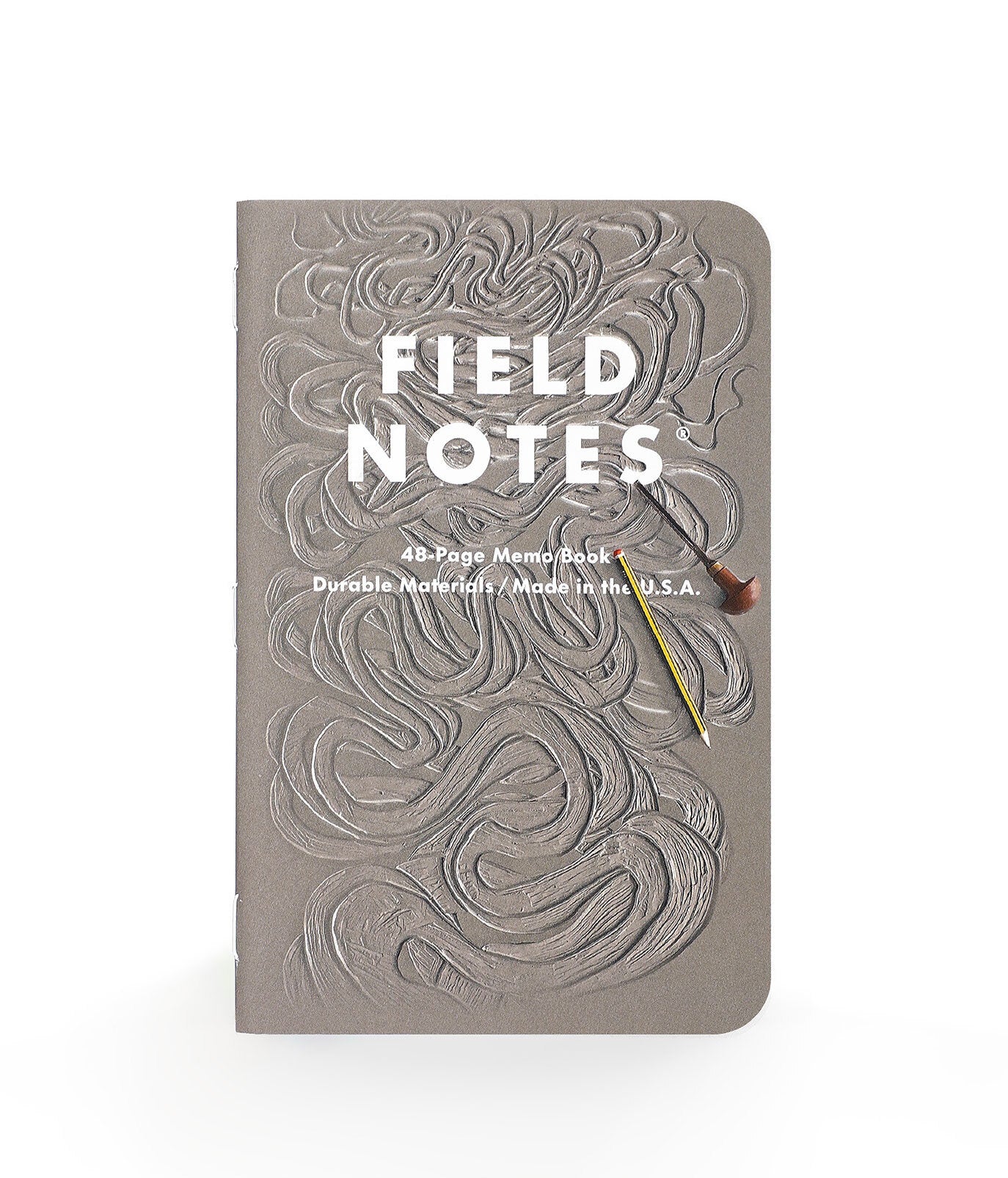 Field Notes notebook with embossed design and a pencil on a white background