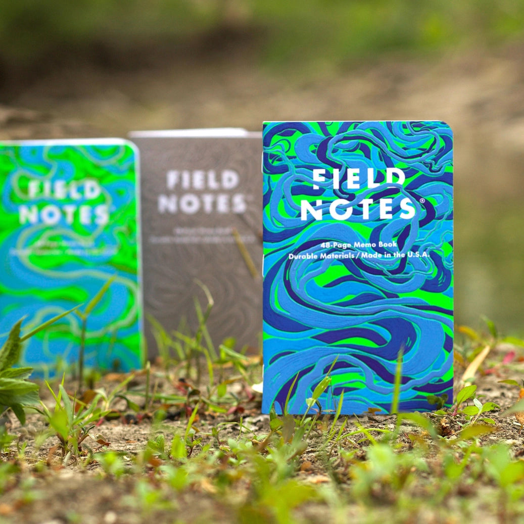 Three Field Notes notebooks with different river colorful designs on a natural background