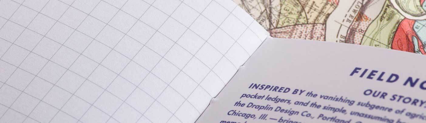 Open notebook with visible text and colorful pages on a grid background