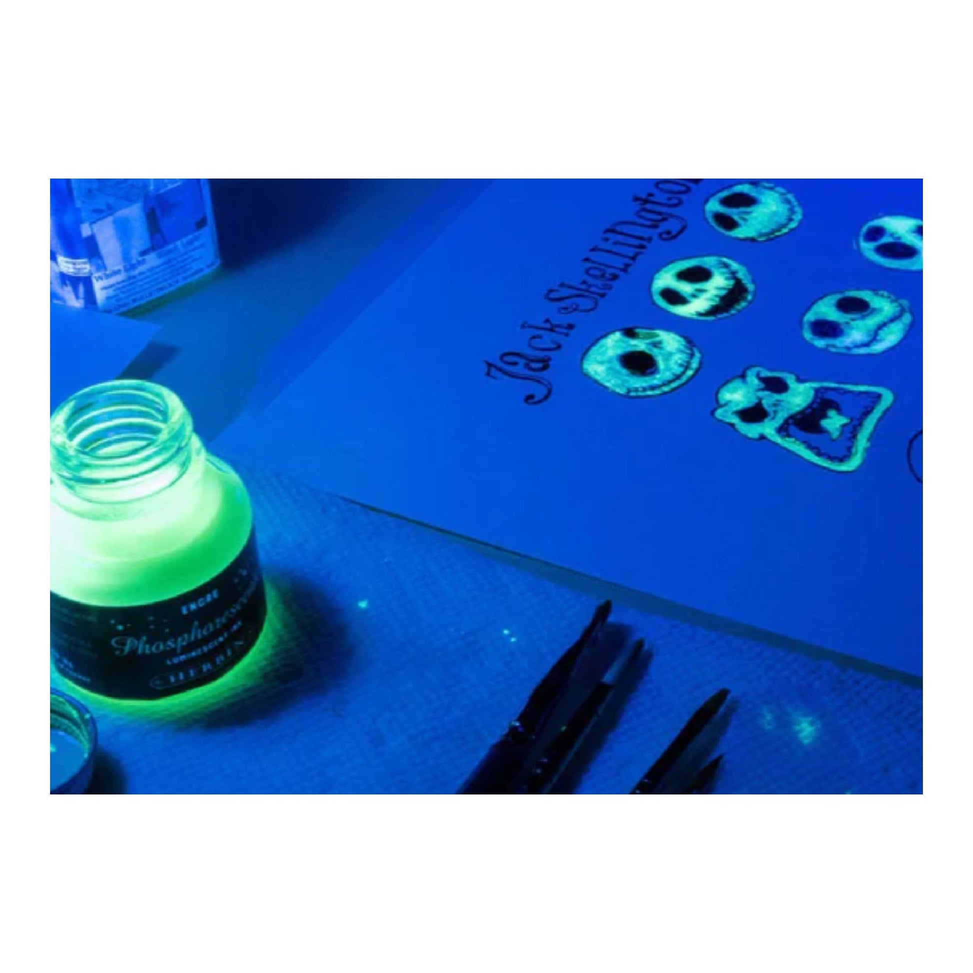 Glow in the dark ink bottle on a blue surface with glowing effect
