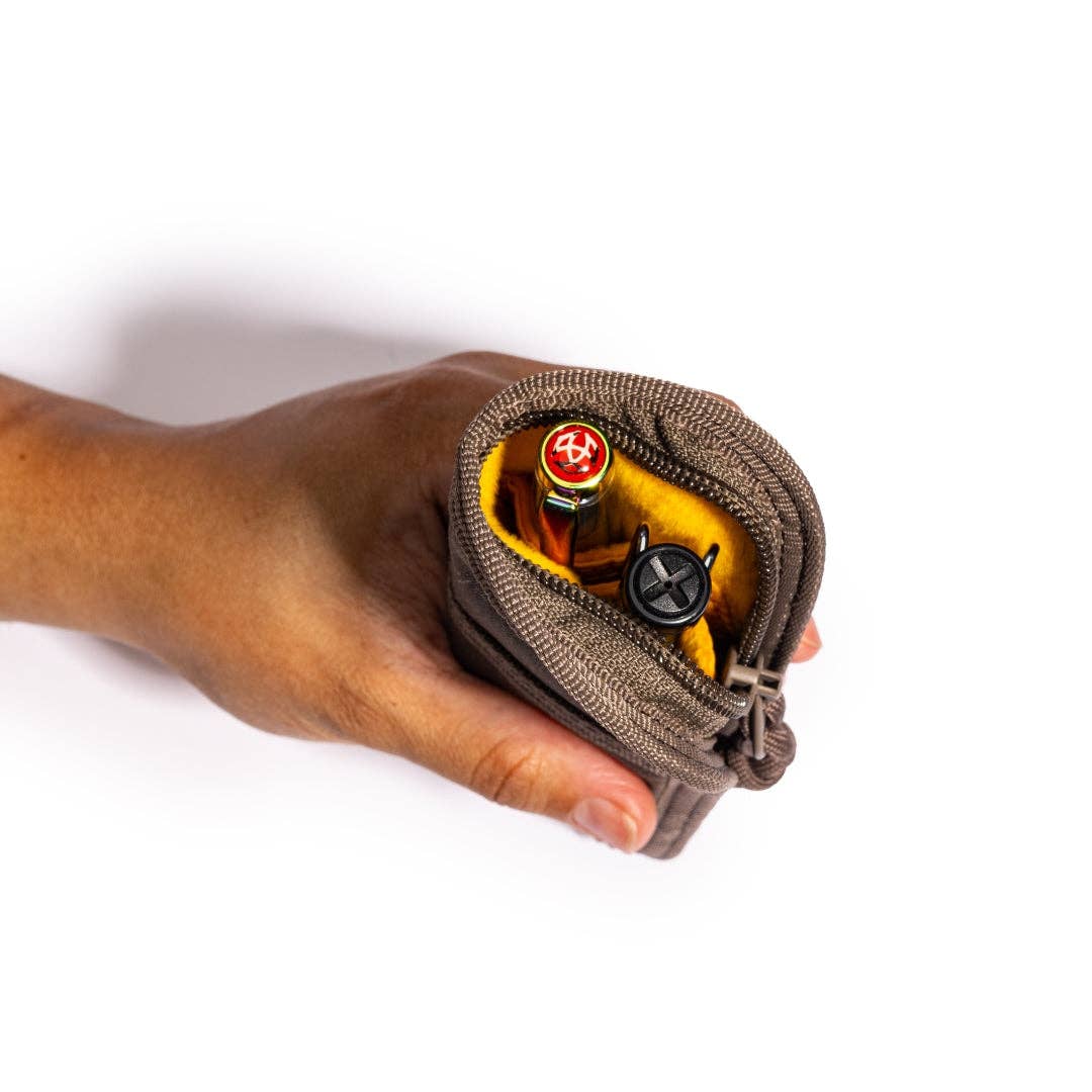 Hand holding a LOCHBY Duo zippered pouch with pens on a white background