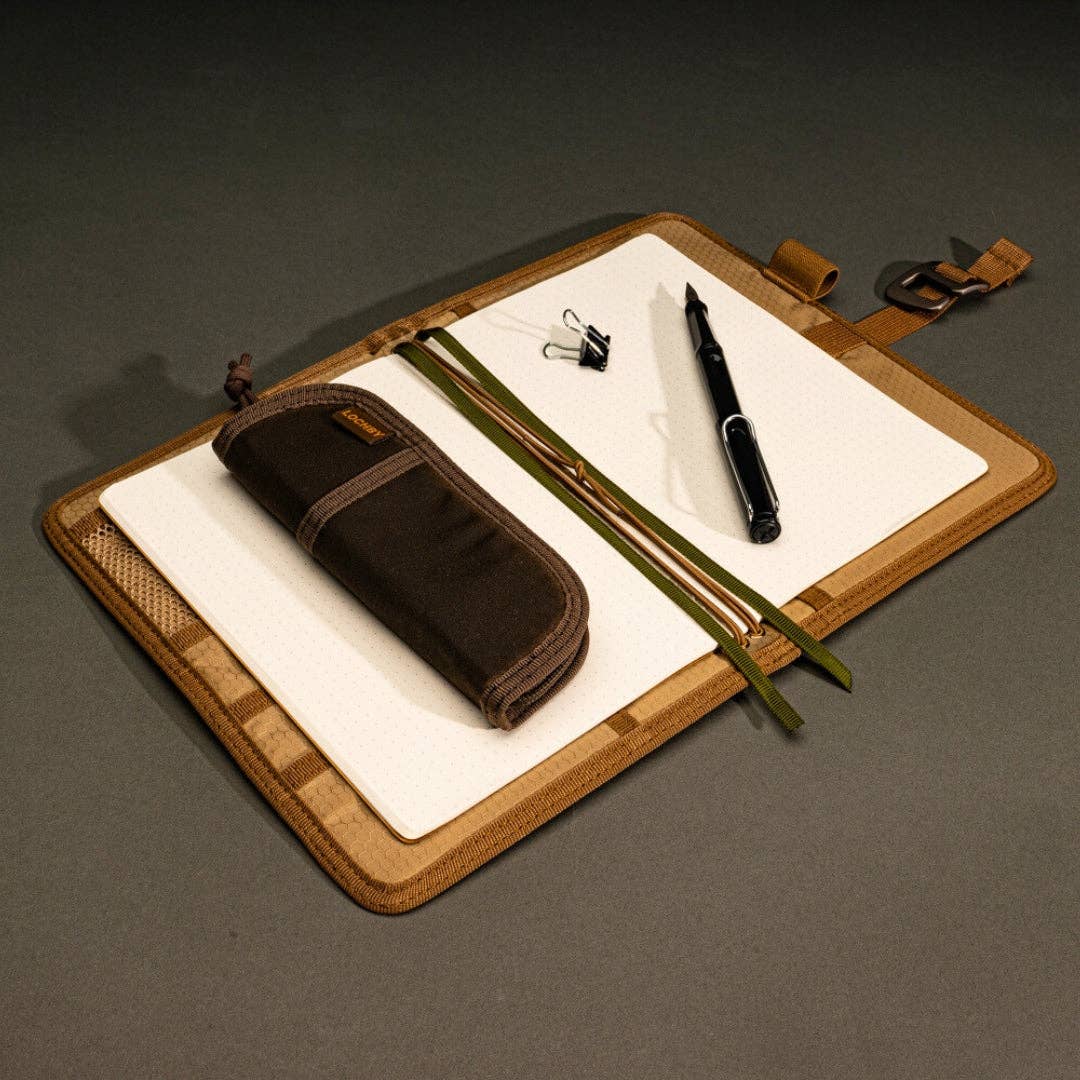 LOCHBY Brown Field Journal with pen, and LOCHBY Duo pen case, and other items on a dark surface