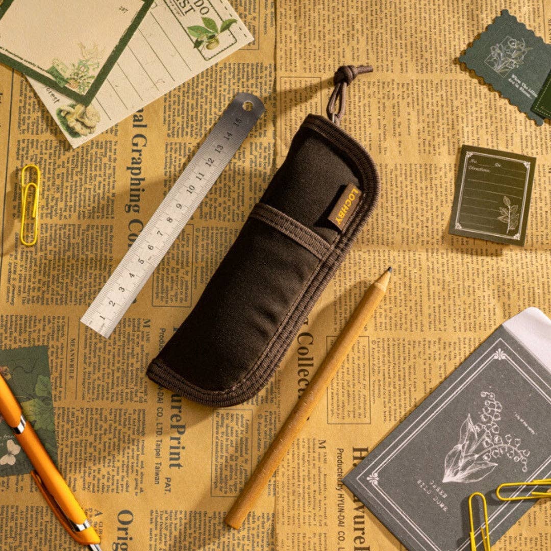 LOCHBY brown pen case on a vintage newspaper background with stationery items.