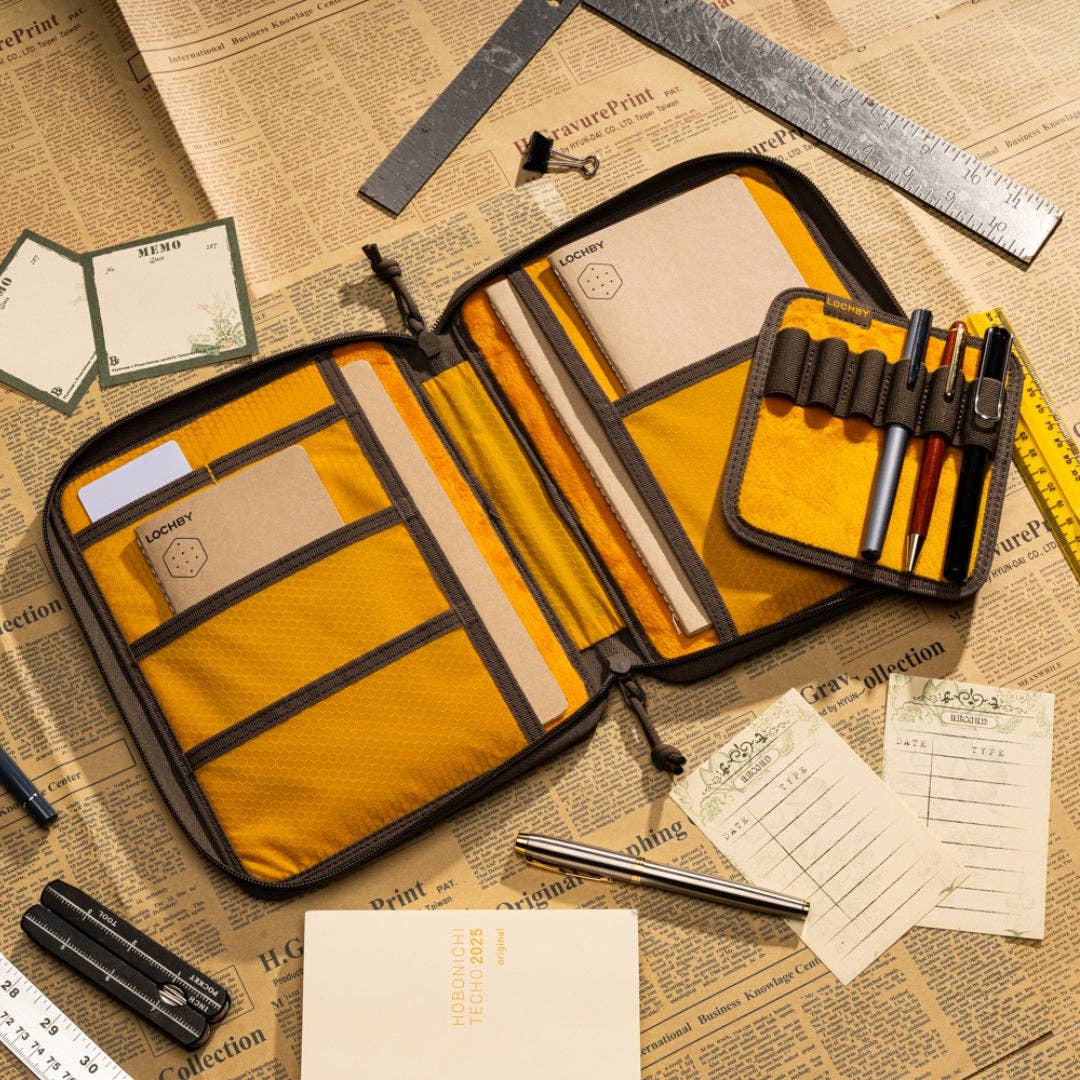 Open LOCHBY Daily folio A5 organizer with stationery items on a newspaper background