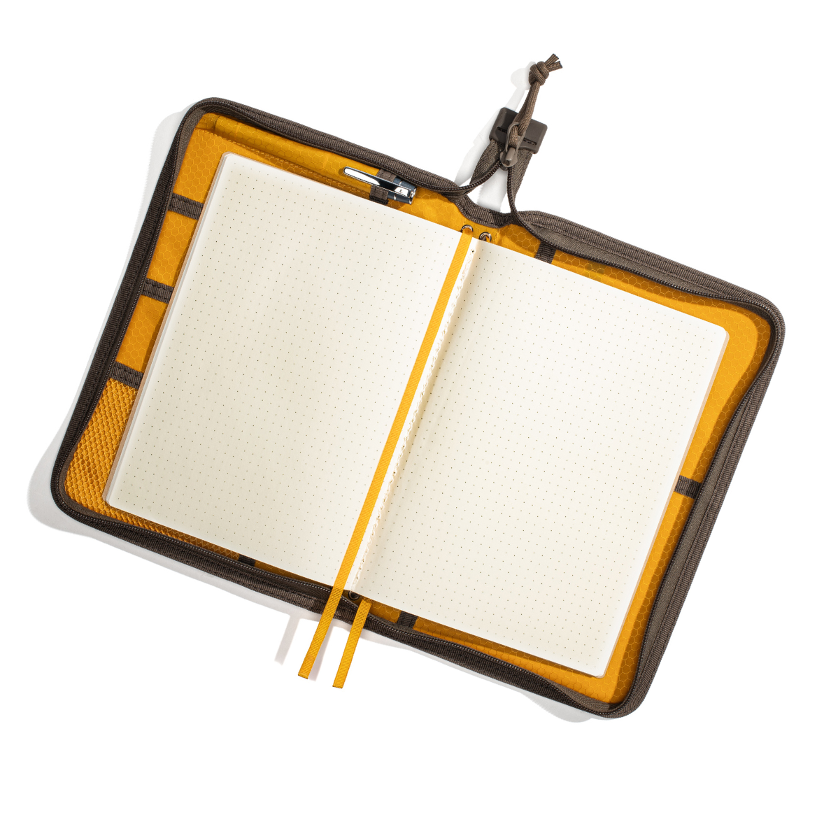 Open notebook with grid paper inside, encased in a black and orange carrying case on a white background.