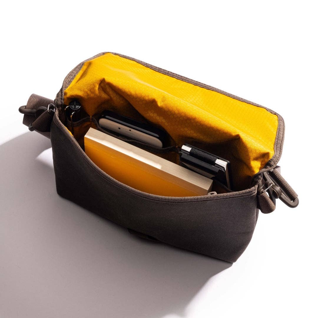 LOCHBY Field Sling with yellow interior and brown exterior containing devices on a white background