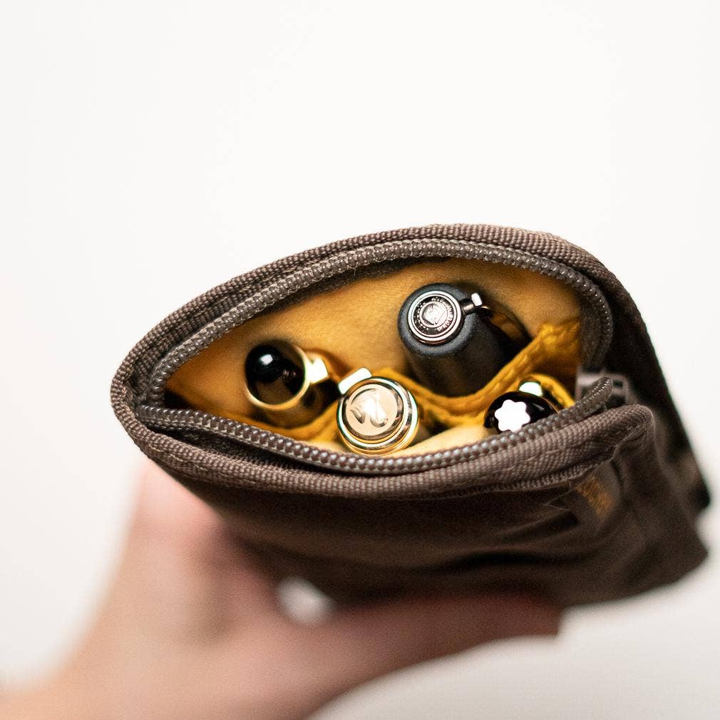 Lochby Quattro Pen Holder in Brown showing pens inside,  held by a hand on a white background