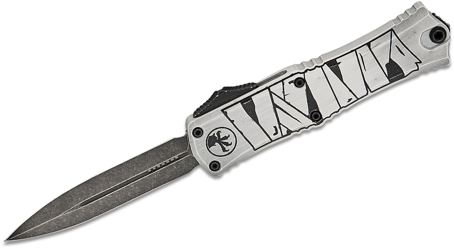 A Microtech Hera II Mini D/E Mummy Wrap Standard Out the Front Knife with a silver-colored blade and black handle featuring intricate engravings.