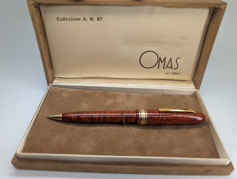 Wooden mechanical pencil with gold accents in a wooden box labeled 'Omas'.