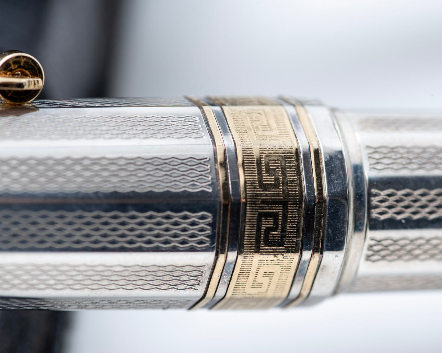 Close-up of a silver and gold pen with intricate design
