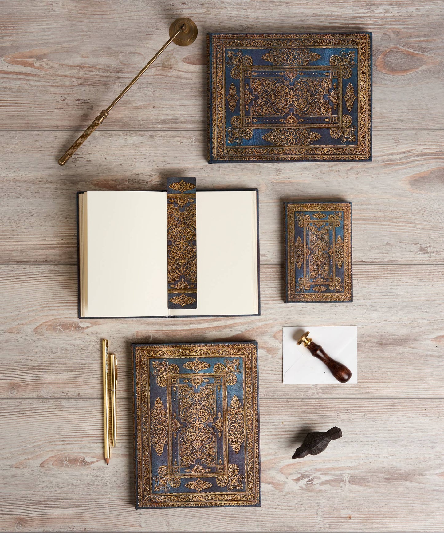 Decorative leather-bound books and writing instruments on a wooden surface