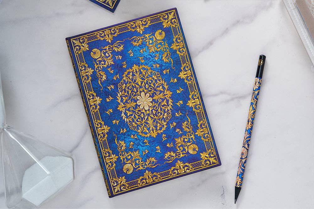 Paperblanks Silk Sky Hardcover Journal Decorative blue notebook with gold patterns on a marble surface