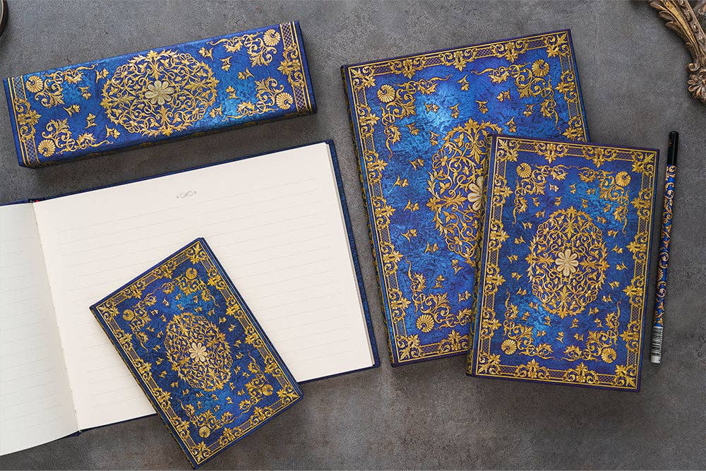 Decorative blue and gold notebooks on a gray surface