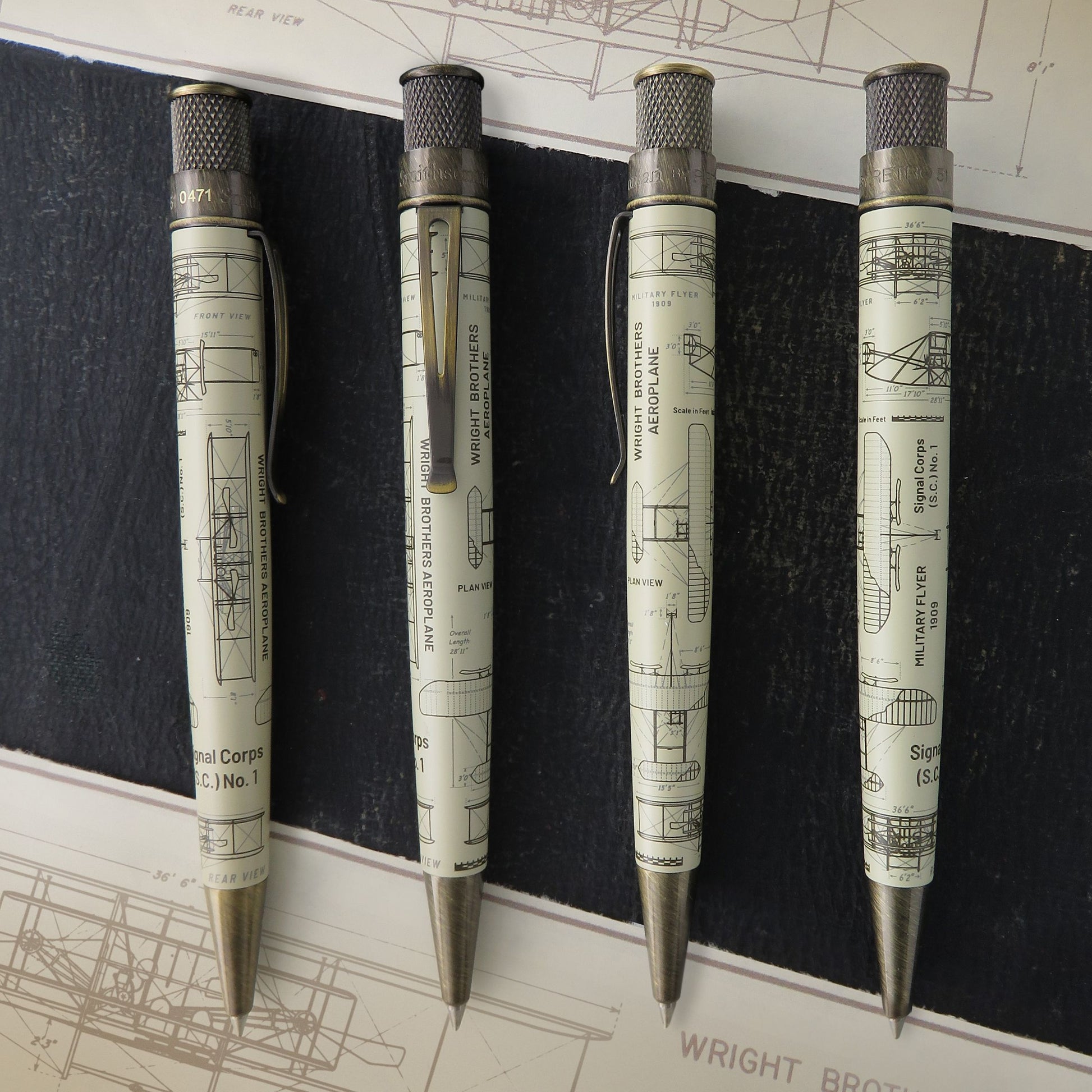 Retro 51 Wright Brothers Aeroplane - Rollerball pen showing all angles with a vintage architectural blueprint print, arranged vertically on a dark textured background with blueprint sheets visible.