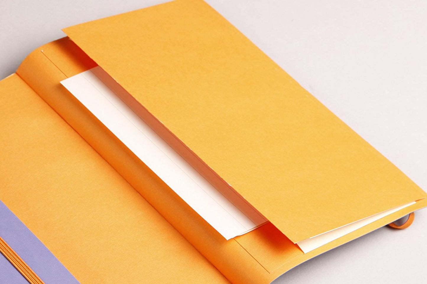 A close-up of Rhodiarama Softcover A6 notebook inner pocket, an  photographed on a light neutral background.