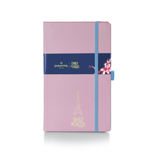 Pink notebook with blue strap and Eiffel Tower design on a white background