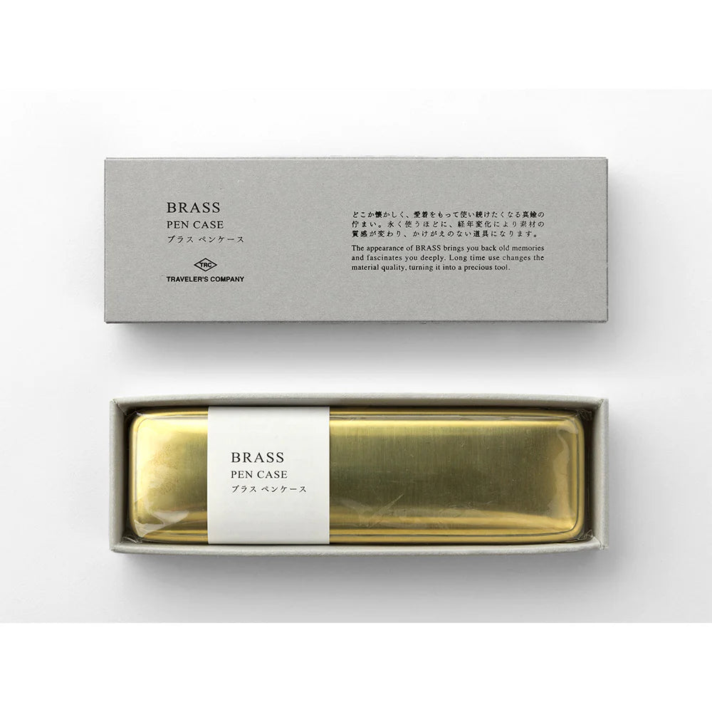 Brass pen case in a box with a label on a white background