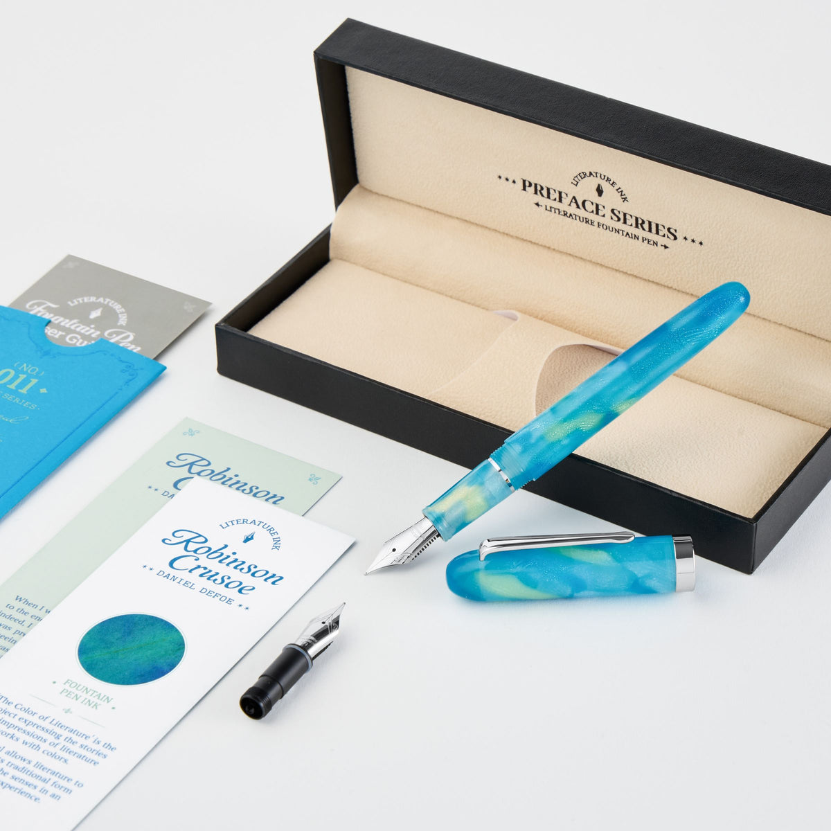 A blue marbled resin fountain pen with a silver nib, shown next to its open black presentation box with beige interior. The box lid is printed with 'PREACE SERIES' and 'ROBINSON CREATIVE'.